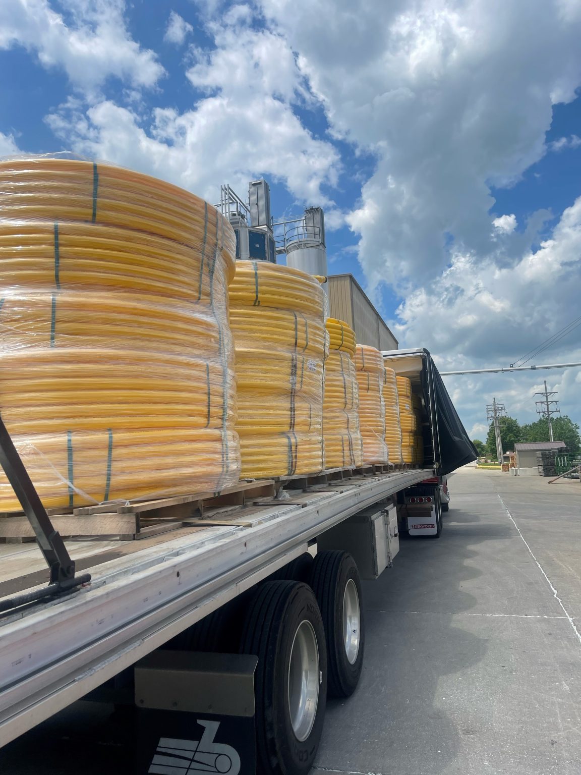 Flatbed truck pulling plastics pipes